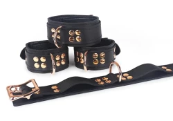 Double strap wrist and ankle cuffs, 1.5" wide. Black leather top and bottom, black lambskin inner lining, reinforced rose-gold d ring in center (upon special request), rose-gold locking buckle