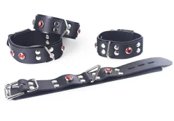 Double strap wrist and ankle cuffs, both are 1.25" wide. Black leather top, rubber bottom, no inner lining, triangle in center, ruby gems, silver locking buckle.