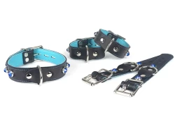 Collar, wrist and ankle cuffs, all 1" wide. Black leather, baby blue lambskin inner lining, silver d ring in center, sapphire dome gems, silver locking buckles.