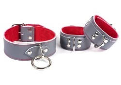 Left: 1.5" wide single strap collar with grey leather, red suede inner lining, silver loop & dee in center. Right: a set of double strap cuffs with grey leather on top and bottom, red suede inner lining, d ring in center.