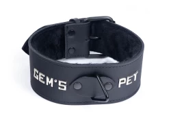 Single strap collar 2" wide. Black leather, black fur inner lining, black triangle in center, lettering, black buckle.