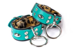 Double strap cuffs, 1.25" wide. Teal leather top, black leather bottom, leopard fur inner lining, silver loop & dee attachments, capsules.